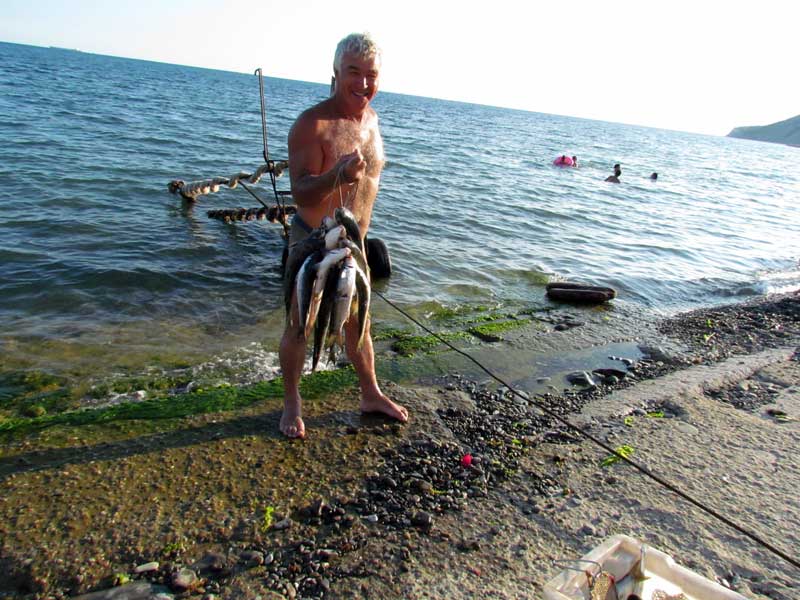 Довольный седой мужичек с не плохим уловом 