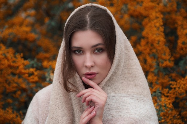 Симпатичная азиатская женщина в хорошем настроении позирует в осенний день, наслаждаясь хорошей погодой. искусство работы романтической женщины. довольно мягкая модель смотрится в камеру.