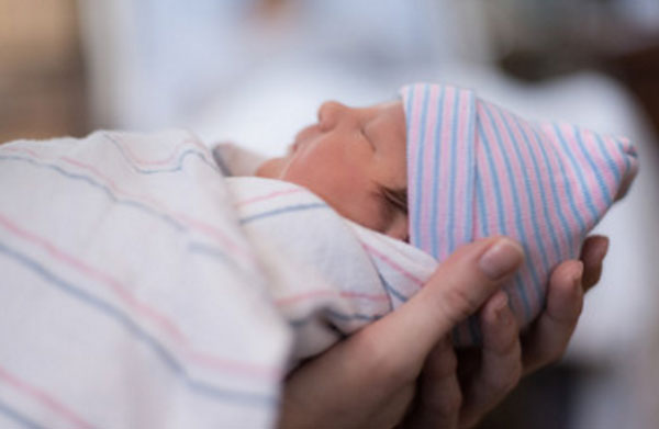 Новорожденный ребенок у мамы на ладошке