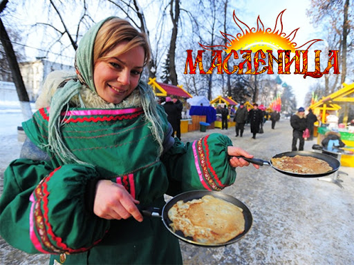 Девушка держит две сковородки с блинами 