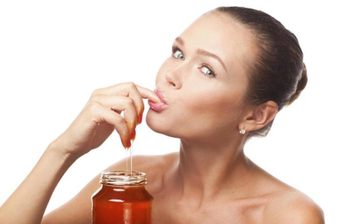 Девушка ест мёд