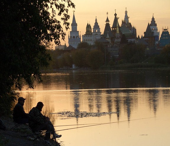 два рыбака с удочками на озере